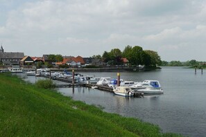 Ein Yachthafen mit vertäuten Booten, einer Brücke und Gebäuden im Hintergrund.