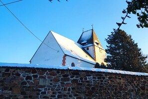 A church with a stone wall in the foreground. - Holiday in the Leipzig New Lakeland (Frohburg)