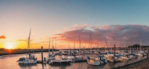 Ein Yachthafen mit mehreren Schiffen, die bei Sonnenuntergang vor Anker liegen.