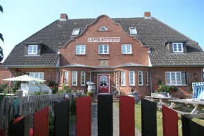 Ein zweistöckiges Backsteingebäude mit roter Tür und der Aufschrift 'Klar Kimming' an der Fassade.