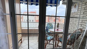 A room with a sliding glass door leading to an outdoor patio with a table and chairs. - Apartment Sleeps 7 With Balcony (Velez-Malaga)