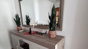 A bathroom vanity with a mirror, two potted plants, a small vase, and a red object on the countertop. - Apartment Sleeps 7 With Balcony (Velez-Malaga)