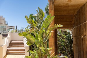 Un escalier menant à une structure en bois, entourée d’une végétation luxuriante de bananiers.