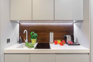 Eine moderne Küche mit eingebautem Herd, einer Spüle und einer Holz-Spritzschutzwand.