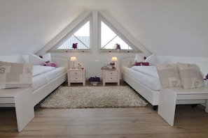 Ein Schlafzimmer mit zwei Betten, einem weißen Teppich und einem Oberlicht.