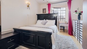 Una camera da letto con un letto, una scrivania e una sedia.