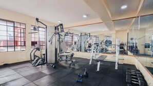 Una palestra con attrezzature per esercizi, una panca e manubri.