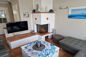 Ein Wohnzimmer mit Fernseher, Kamin und Sitzecke.