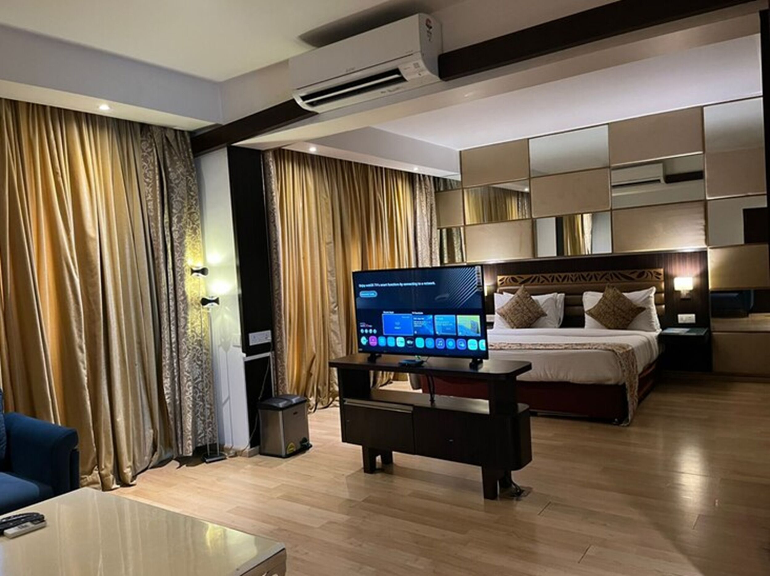 A hotel room with a bed, a TV, a desk, and curtains.