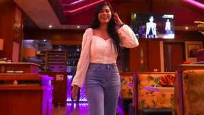 Una persona está de pie en un restaurante, con un televisor al fondo.