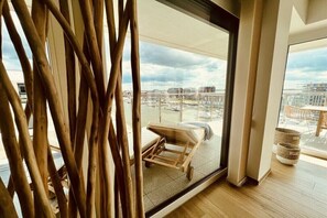 A modern interior with a large glass door leading to a balcony with a view of a cityscape. - Holiday apartment with 3 bedrooms (Bremerhaven)