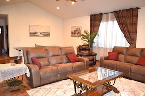A living room with two sofas, a coffee table, a chair, and a plant.
