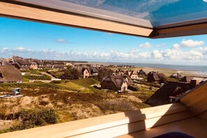 Een kustdorp met traditionele huizen, een strand en een heldere lucht.