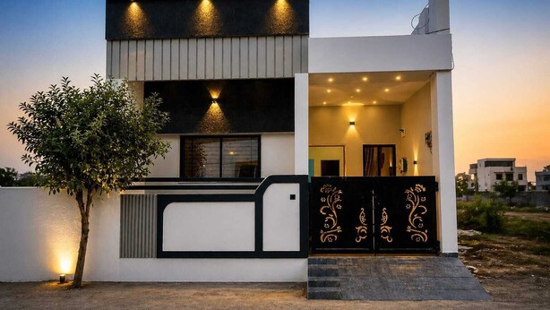 A modern two-story house with a balcony, a small tree, and a decorative gate. - Shivansh Stays (Ujjain)