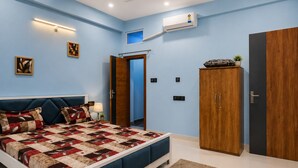 A bedroom with a bed, wardrobe, and an air conditioning unit. - Shivansh Stays (Ujjain)