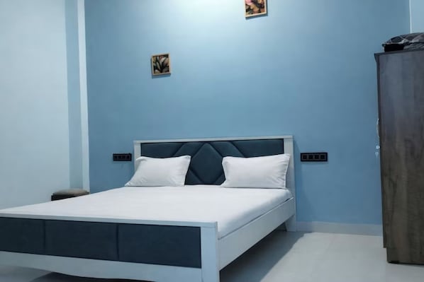 Un dormitorio moderno con una cama, un armario y dos interruptores de luz en la pared.