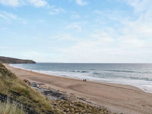 A coastal beach with a rocky foreground, a sandy shore, and a clear sky. - 2 bedroom accommodation in Porthleven (Porthleven)