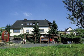 Ein zweistöckiges Gebäude mit einem Schild, auf dem 'Rebenhof' steht.