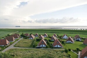 Et boligområde med huse, en vej og et vandareal i baggrunden.