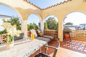 Eine Terrasse mit Tisch, Stühlen und einem Grill.