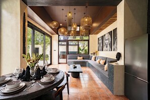 Un intérieur moderne comprenant un coin repas, un espace salon avec un canapé et une cuisine.