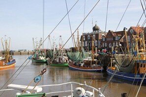Ein Hafen mit mehreren vertäuten Fischerbooten, ein Gebäude mit einer Kuppel und einem klaren Himmel.