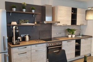 Eine moderne Küche mit integrierten Geräten, Holzschränken und Topfpflanzen.