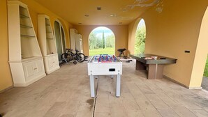A spacious indoor area with a foosball table, a bicycle, and a table tennis table. - Luxury Villa with Panoramic Terrace - 5 rooms (Toscana)