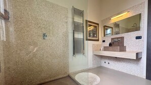 A modern bathroom with a glass shower enclosure, a built-in sink with a mirror, and a tiled backsplash. - Luxury Villa with Panoramic Terrace - 5 rooms (Toscana)
