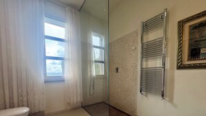 A bathroom with a toilet, a shower with a glass door, a towel rack, and a framed picture on the wall. - Luxury Villa with Panoramic Terrace - 5 rooms (Toscana)