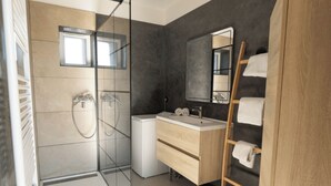 A modern bathroom with a glass shower enclosure, a wooden vanity, and a mirror. - L'Atelier Vacation Rental (Wierre-Effroy)
