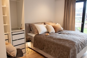 Una camera da letto con un letto, un comodino, una sedia, un armadio e vista sull'esterno.