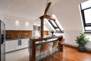 Eine moderne Küche mit einer Holzinsel, weißen Schränken und einem Oberlicht.