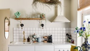 A kitchen with a white sink, a wooden countertop, a hanging basket, and a vase with flowers. - Brand new 2-bedroom cottage in centre of Zandvoort 500m to the beach (Zandvoort)