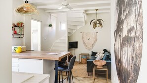 A modern interior with a kitchen, dining area, and living space, featuring a staircase, pendant lights, and a large wall mural. - Brand new 2-bedroom cottage in centre of Zandvoort 500m to the beach (Zandvoort)