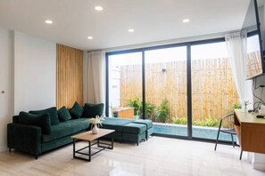 Ein modernes Wohnzimmer mit Sofa, Couchtisch und Schreibtisch.