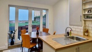 Una cocina moderna con tragaluz, una zona de comedor con sillas y vistas al exterior.