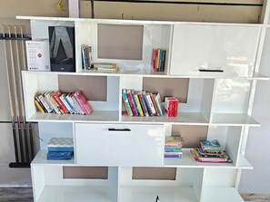 Une étagÚre blanche contenant des livres et un lecteur DVD.
