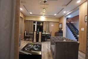 A modern living room with a sofa, a coffee table, and a dining area with a table and chairs.