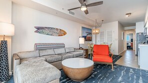 Een moderne woonkamer met een bank, een rond bijzettafeltje en een opvallende rode fauteuil.