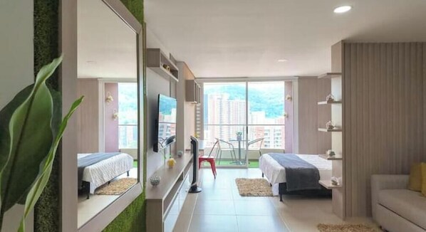 Una habitación de hotel moderna con balcón, televisión, escritorio y cama.
