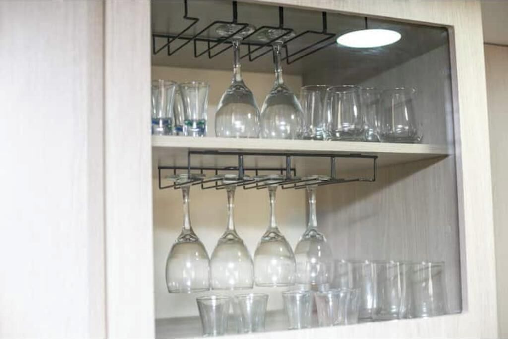 Una estantería con copas de vino y vasos.