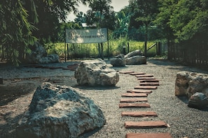 Un sendero con rocas grandes y un cartel que dice 'REST TIME BAMBOO'.