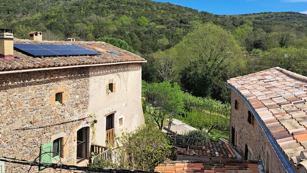 A stone building with a tiled roof, a small window, and a staircase leading to a door. - Authentic 13th-century Cévennes house (Thoiras-Corbès)