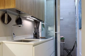 A modern kitchen with a white countertop, stainless steel sink, and overhead lighting. - Hostmate - Bari - Putignani (Bari)
