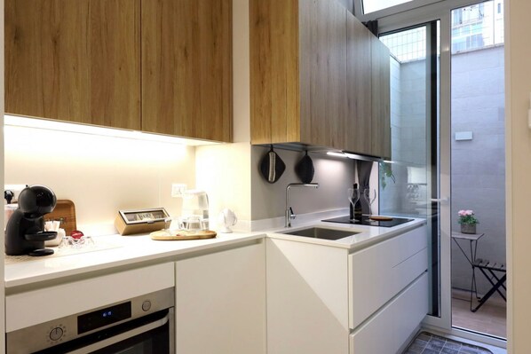 A compact kitchen with a built-in oven, a coffee maker, and a sink. - Hostmate - Bari - Putignani (Bari)