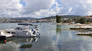 Un port de plaisance avec des bateaux amarrés, une eau calme et une ville lointaine avec ses bâtiments.