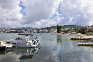 Ein Yachthafen mit vertäuten Booten, ruhigem Wasser und einer in der Ferne liegenden Stadt mit Gebäuden.