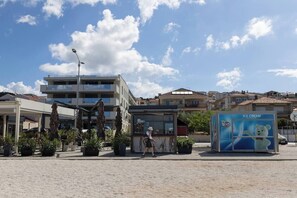 Ein öffentlicher Platz mit einer Kiosk, einem modernen Gebäude und einem Schild für Eis.