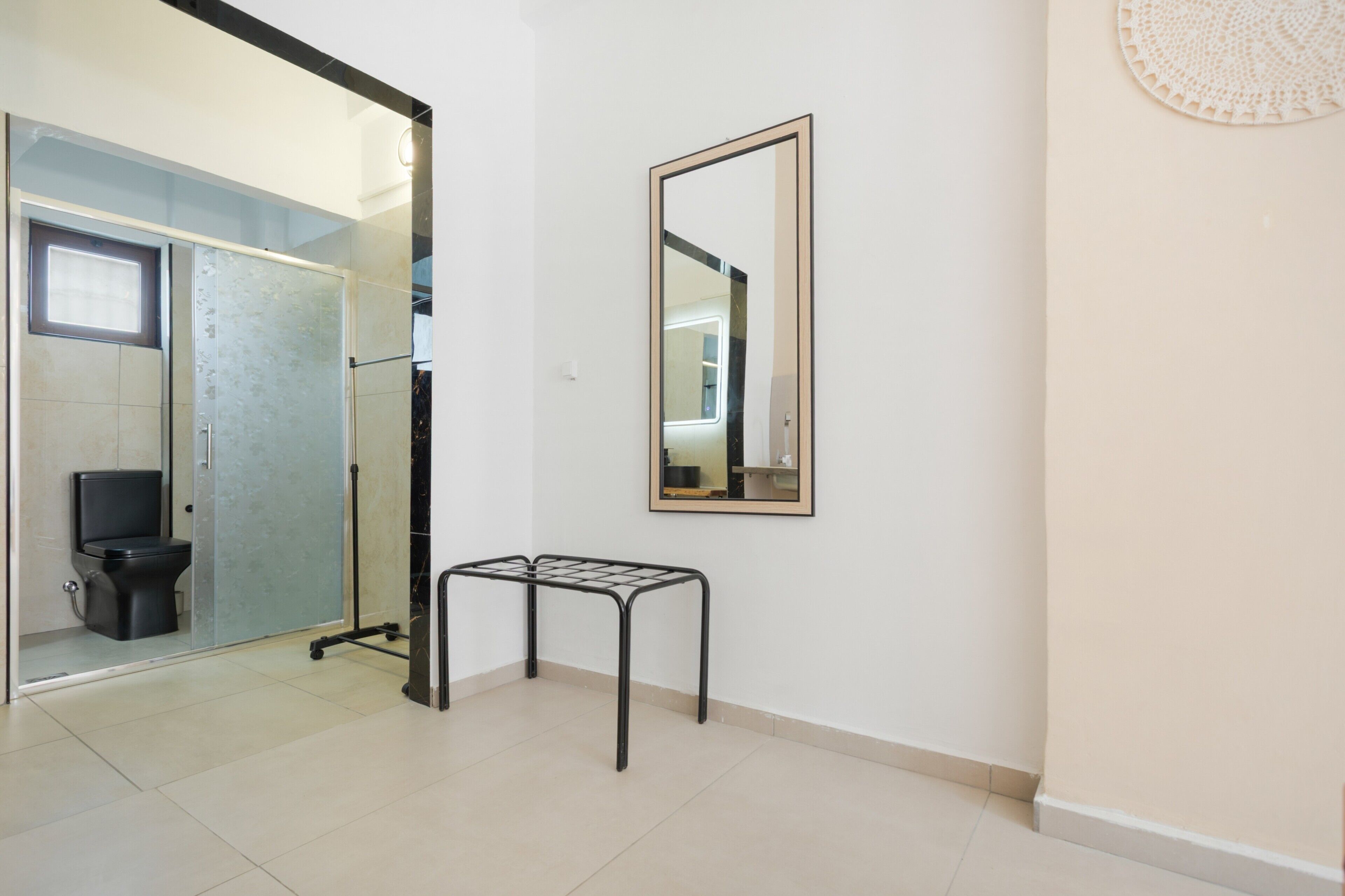 A bathroom with a toilet, a shower, and a mirror on the wall.